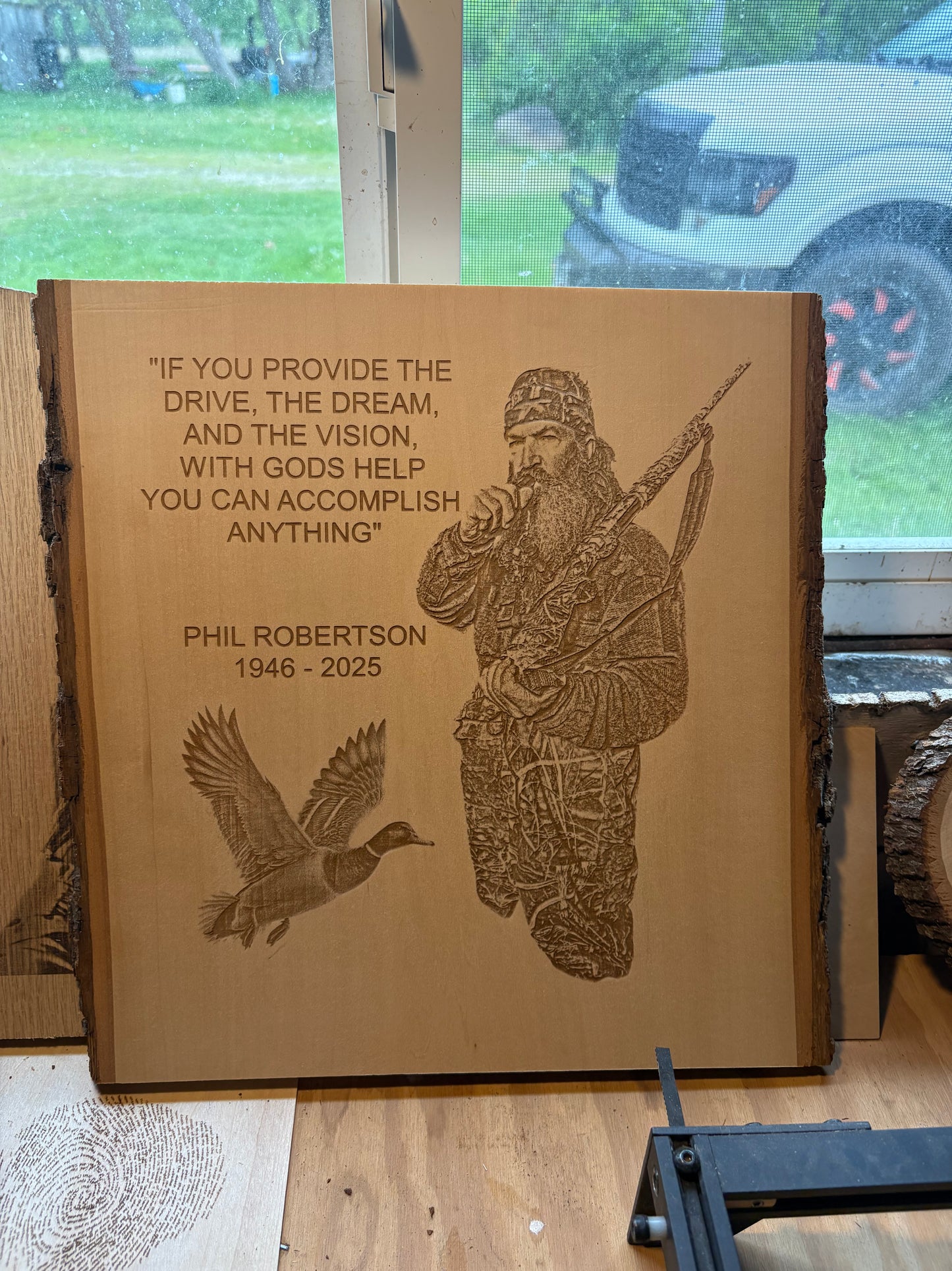 Engraved wooden plaque with a hunting scene and engraved text on a table.